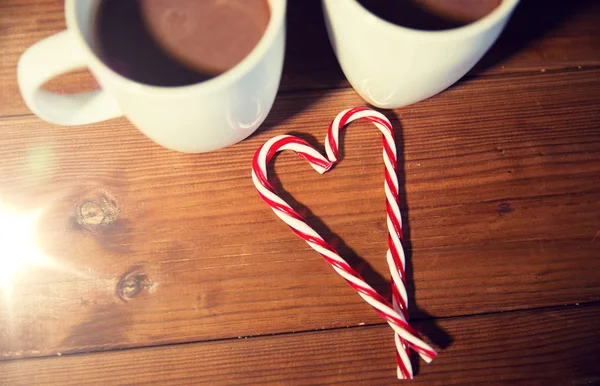 Bastones y copas de caramelo de Navidad en la mesa de madera —  Fotos de Stock