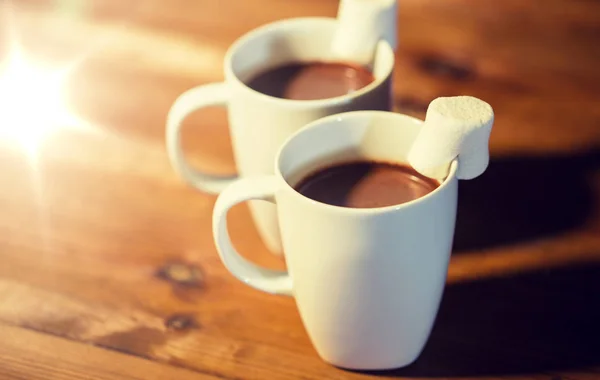 Чашки горячего шоколада с зефиром на дереве — стоковое фото