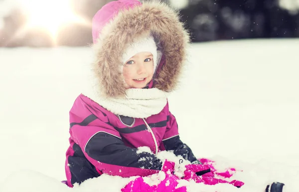 Niño feliz en ropa de invierno jugando con la nieve — Foto de Stock