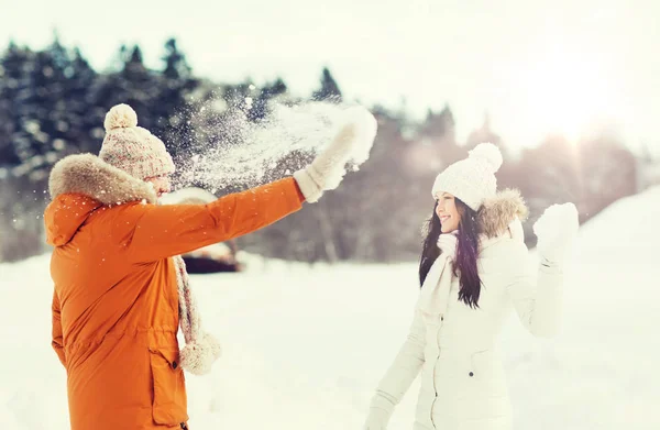 Feliz pareja jugando con nieve en invierno — Foto de Stock