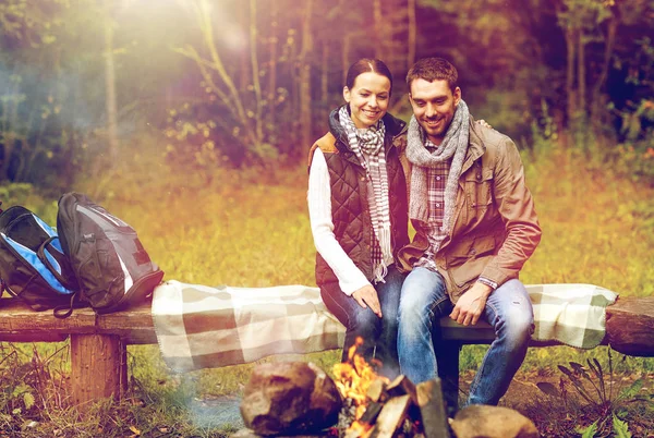 キャンプの火の近くのベンチに座って幸せなカップル — ストック写真