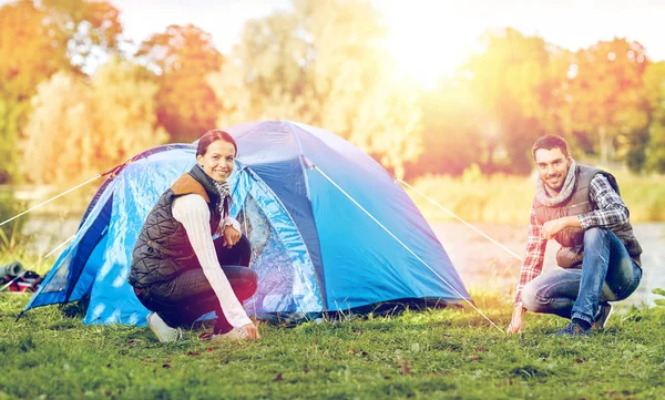 Lyckliga par inställningen upp tält utomhus — Stockfoto