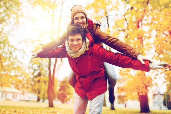 Feliz pareja joven divirtiéndose en el parque de otoño —  Fotos de Stock