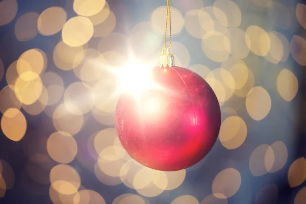 Zbliżenie na czerwoną piłkę Bożego Narodzenia nad złote światło — Zdjęcie stockowe
