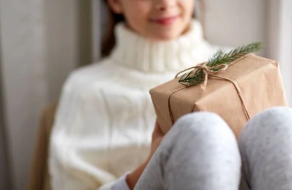 Flicka med julklapp sitter på sill hemma — Stockfoto