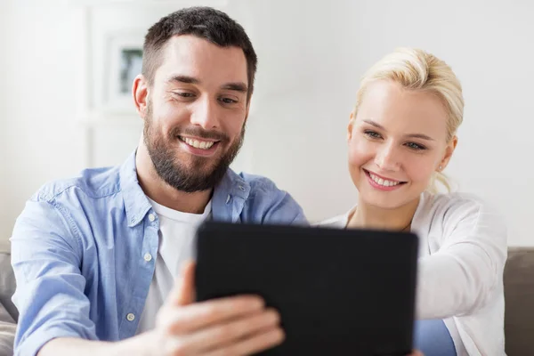 Sorrindo casal feliz com tablet pc em casa — Fotografia de Stock