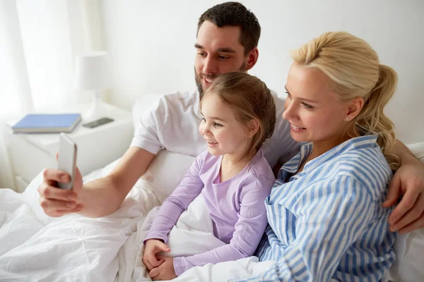 Happy family taking selfie by smartphone at home — Stock Photo, Image