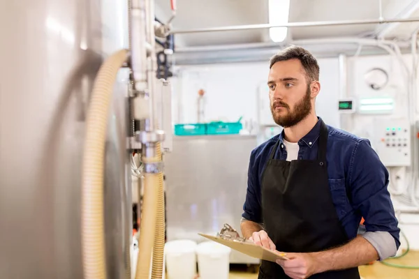 Hombre con portapapeles en cervecería artesanal o fábrica de cerveza — Foto de Stock