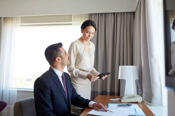 Equipe de negócios com papéis que trabalham no quarto de hotel — Fotografia de Stock