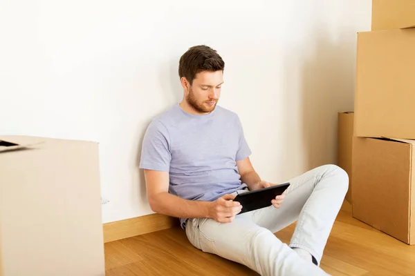 Homme avec tablette PC et boîtes déménageant dans une nouvelle maison — Photo