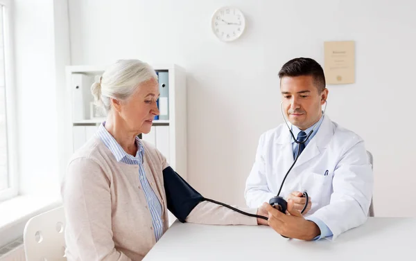 Senior woman and doctor with tonometer at hospital — Stock Photo, Image