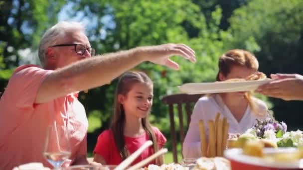 Glückliche Familie beim Abendessen oder Sommerfest im Garten — Stockvideo