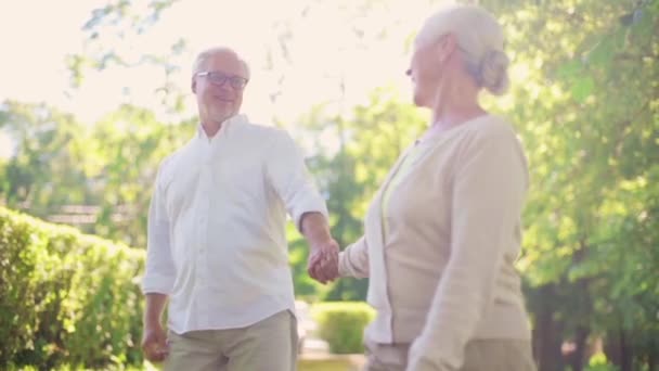 Gelukkige senior paar wandelen in zomer city park — Stockvideo