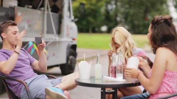 Hombre tomando vídeo de amigos comiendo en comida camión — Vídeo de stock