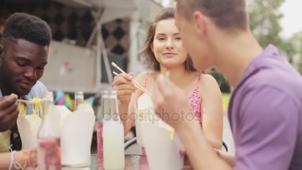 Happy πολυφυλετικής φίλοι τρώγοντας wok στο φορτηγό τροφίμων — Αρχείο Βίντεο