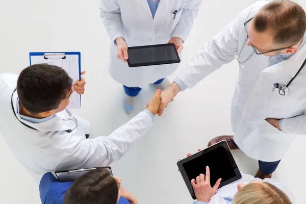 Medici con tablet pc che fanno stretta di mano in ospedale — Foto Stock