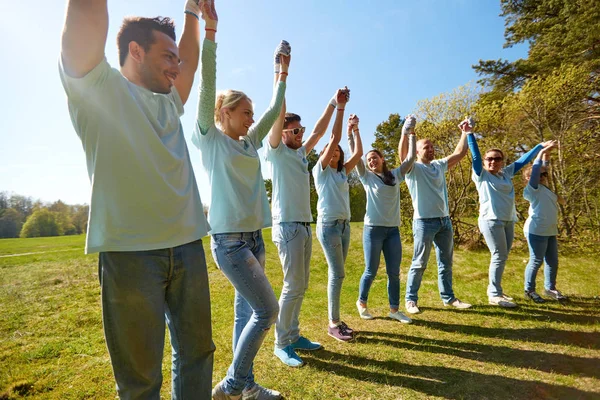 Grupo de voluntários felizes de mãos dadas ao ar livre — Fotografia de Stock