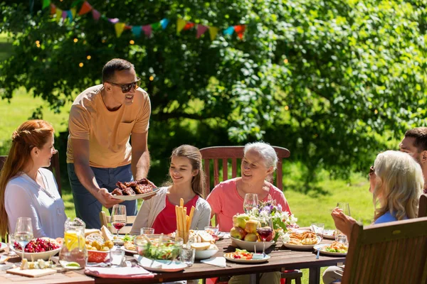 Glückliche Familie beim Abendessen oder Sommerfest im Garten — Stockfoto