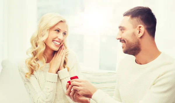 Hombre feliz dando anillo de compromiso a la mujer en casa — Foto de Stock