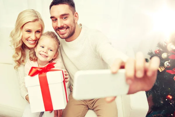 Family taking selfie with smartphone at christmas — Stock Photo, Image