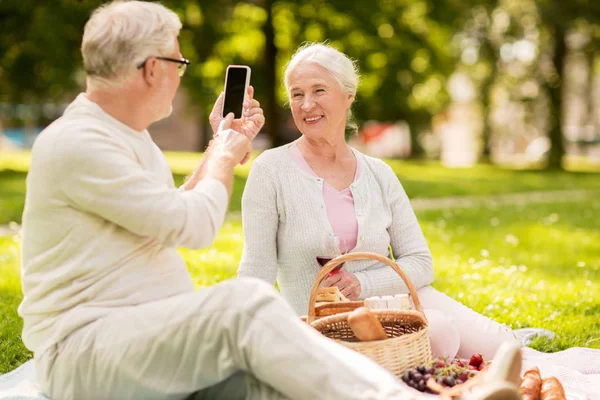 Senior paar nemen foto door smartphone bij park — Stockfoto