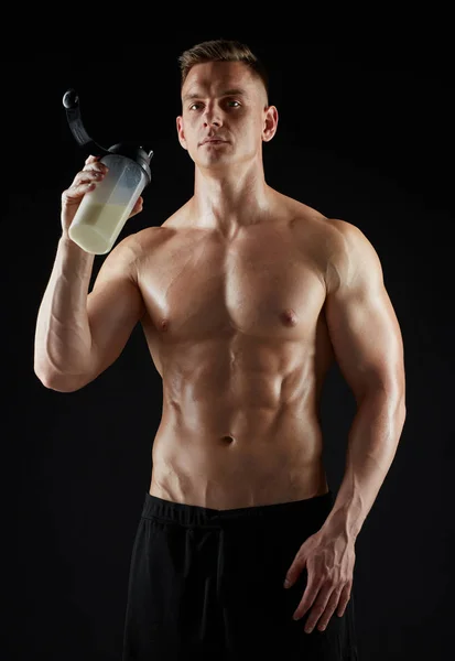 Mladý muž nebo kulturista s proteinem protřepejte láhev — Stock fotografie