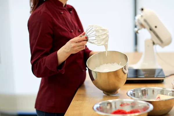 Šéfkuchař s rozšleháme a našlehaných bílcích v kuchyni — Stock fotografie