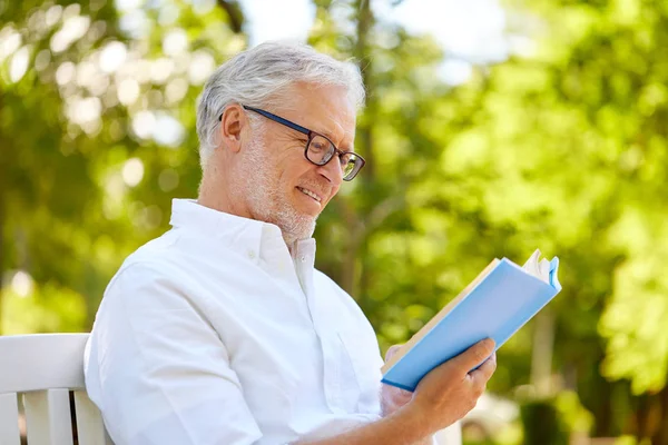 Feliz hombre mayor leyendo libro en el parque de verano — Foto de Stock