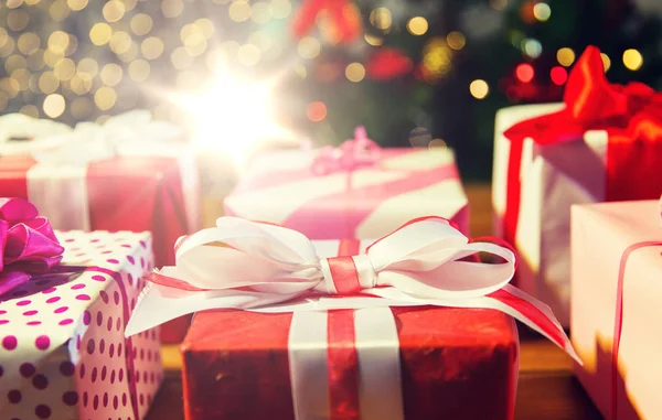 Primer plano de las cajas de regalo sobre las luces del árbol de Navidad — Foto de Stock