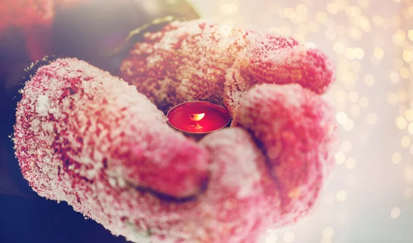Nahaufnahme von Händen in Winterhandschuhen mit Kerze — Stockfoto