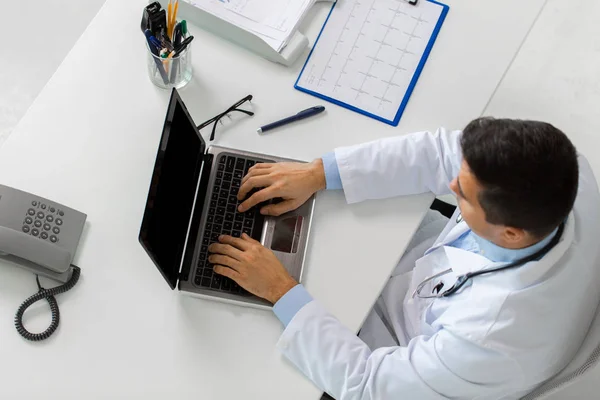 Doctor with cardiogram and laptop at clinic — Stock Photo, Image