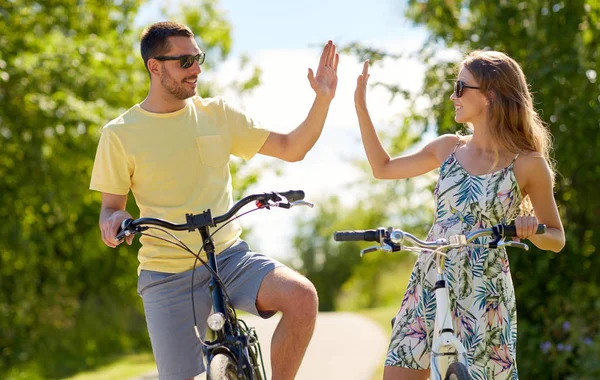 Casal feliz com bicicletas fazendo alta cinco — Fotografia de Stock