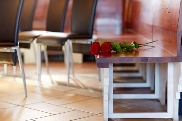 Red roses on bench at funeral in church — Stock Photo, Image