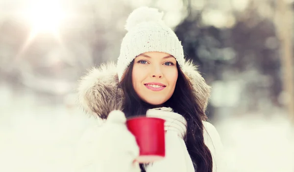 Heureuse jeune femme avec tasse de thé en plein air en hiver — Photo