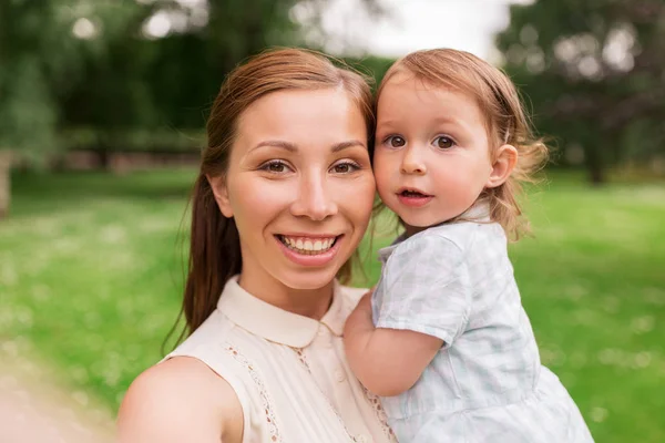 Mother with baby girl taking selfie at summer park — Stock Photo, Image