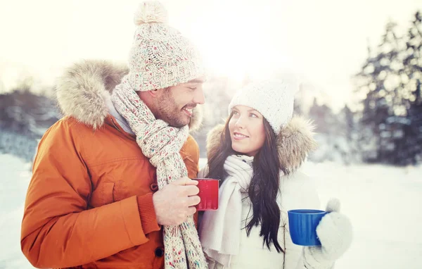 Coppia felice con tazze da tè sul paesaggio invernale — Foto Stock