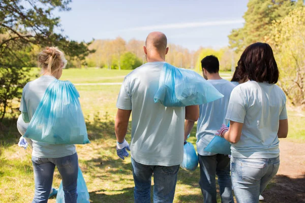 Grupp av frivilliga med soppåsar i park — Stockfoto