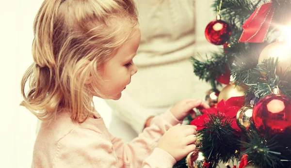 Niña decorando el árbol de Navidad en casa —  Fotos de Stock