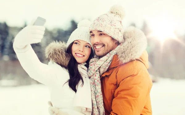 Casal feliz tomando selfie por smartphone no inverno — Fotografia de Stock