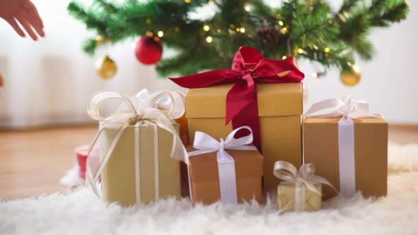 Τα χέρια που παίρνετε δώρο κουτί κάτω από το χριστουγεννιάτικο δέντρο — Αρχείο Βίντεο