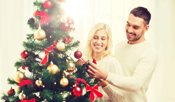 Happy couple decorating christmas tree at home — Stock Photo, Image