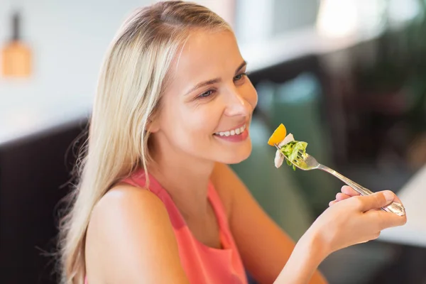 Heureuse jeune femme manger au restaurant — Photo