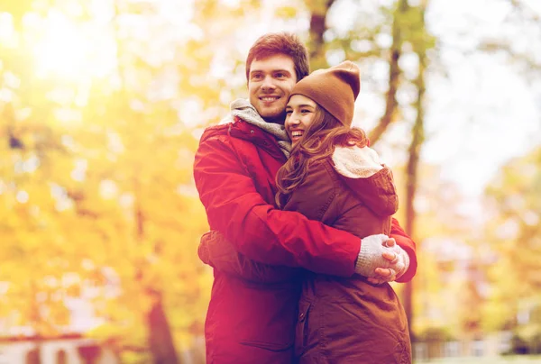 Feliz pareja joven abrazándose en el parque de otoño — Foto de Stock