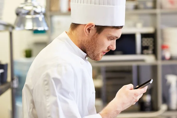 Close up of chef with smartphone at kitchen — Stock Photo, Image