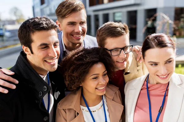 Persone felici con badge per conferenze che scattano selfie — Foto Stock