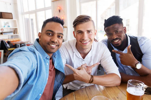 Friends taking selfie and drinking beer at bar — Stock Photo, Image
