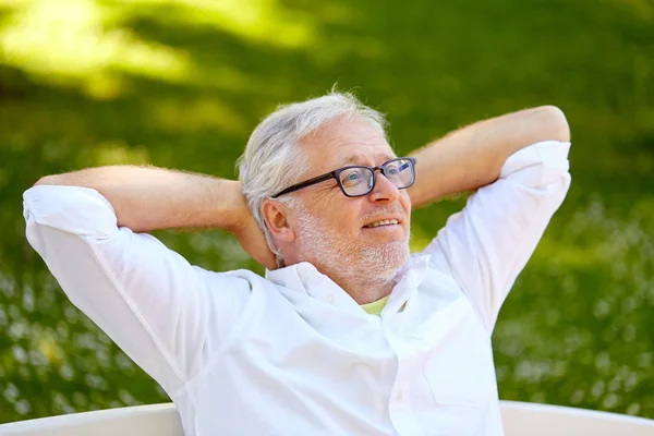 Ευτυχής ανώτερος άνθρωπος κάθεται στο πάρκο καλοκαίρι γυαλιά — Φωτογραφία Αρχείου