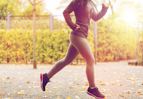 Primer plano de la joven corriendo en el parque de otoño — Foto de Stock