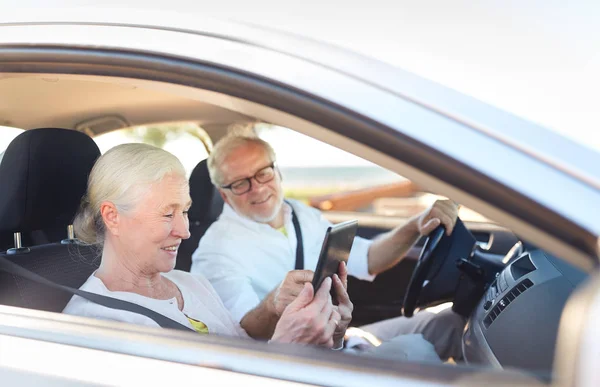 Gelukkige senior paar met tablet pc rijden in auto — Stockfoto