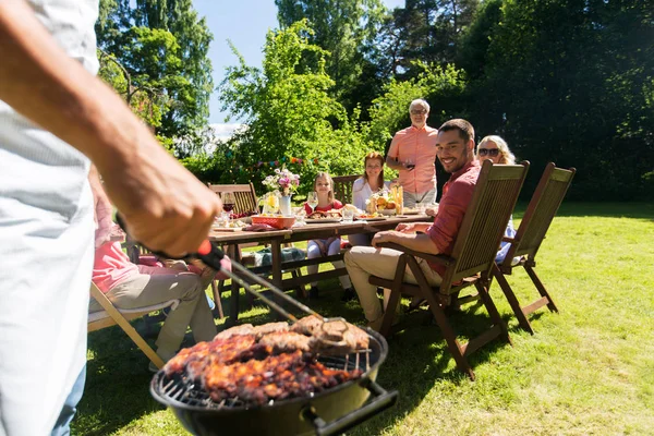 Homem cozinhar carne na churrasqueira na festa de verão — Fotografia de Stock